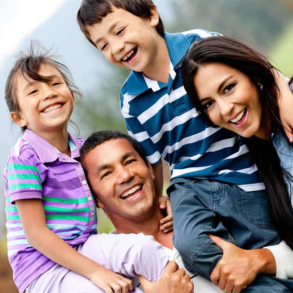 Happy family smiling, patients of our dental office in Coral Gables.